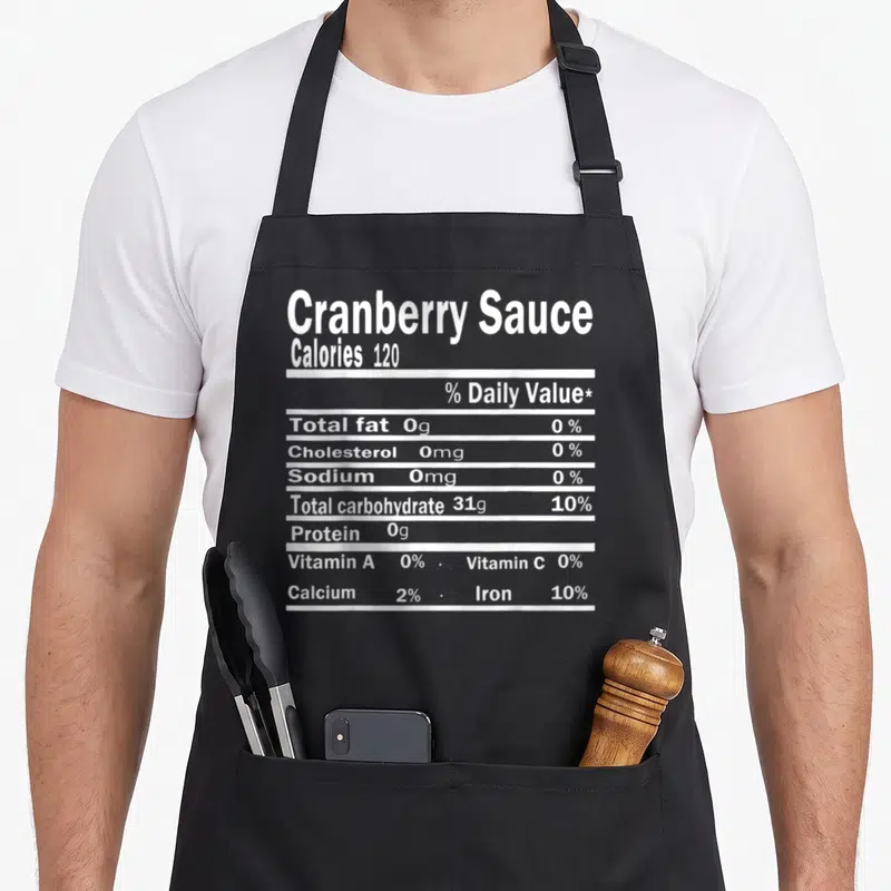 Sauce nutrition costume thanksgiving apron - White typography listing calories and nutrients in a stacked nutrition — shown on a black cotton canvas apron against a white background