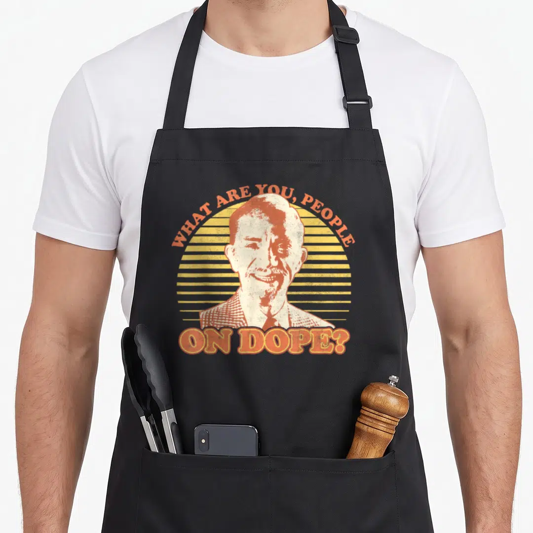 Fast mr apron - Distressed man portrait with orange text WHAT ARE YOU PEOPLE ON DOPE over yellow striped sun — shown on a black cotton canvas apron against a white background