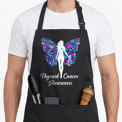 Awareness product thyroid apron - White woman silhouette with butterfly wings holding ribbon and Thyroid Cancer — shown on a black cotton canvas apron against a white background