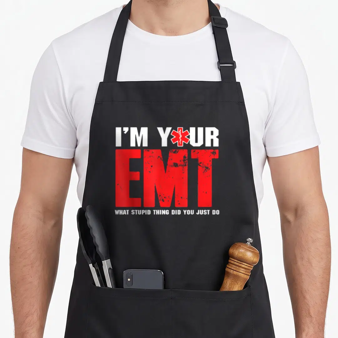 Paramedic ambulance guy apron - Red and white text I'M YOUR EMT with Star of Life symbol replacing the O in YOUR — shown on a black cotton canvas apron against a white background