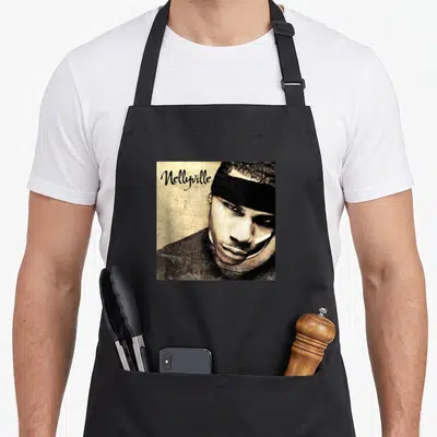 Nellyville cover apron - Man in black headband with Nellyville script text on tan background — shown on a black cotton canvas apron against a white background