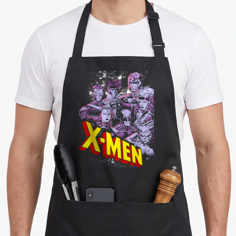Cute x apron - Yellow 3D X-MEN text over purple monochromatic superhero group art — shown on a black cotton canvas apron against a white background