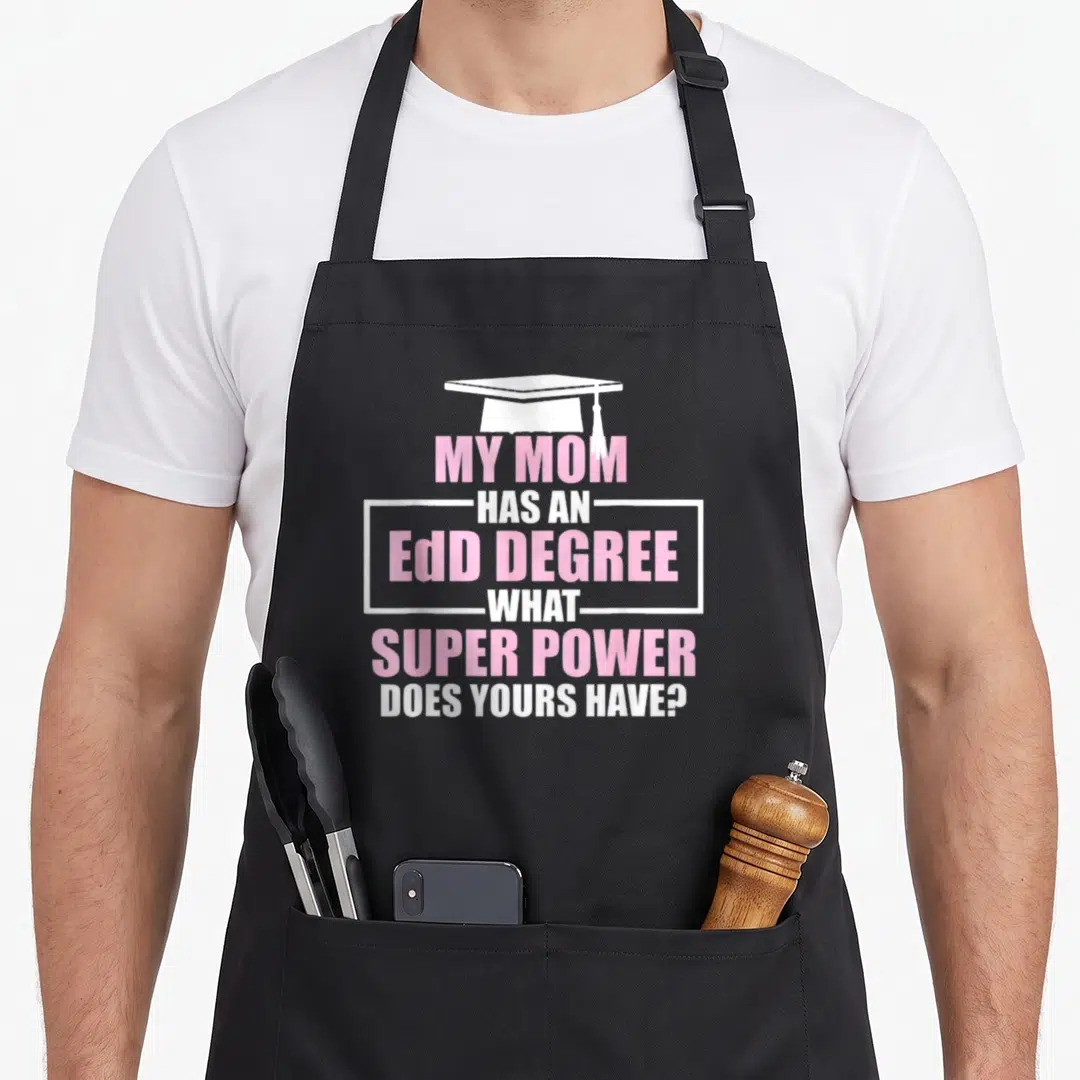Edd education doctor apron - White graduation cap above pink and white text about EdD degree superpower — shown on a black cotton canvas apron against a white background