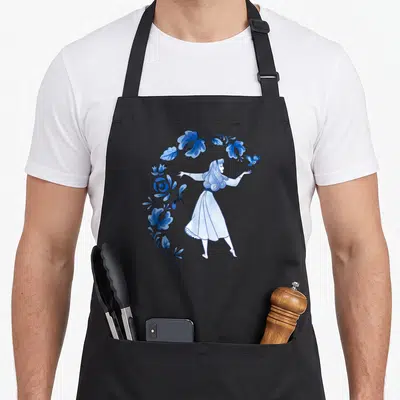 Blue beauty apron - Watercolor woman in white dress reaching for blue bird, surrounded by blue flowers and leaves — shown on a black cotton canvas apron against a white background