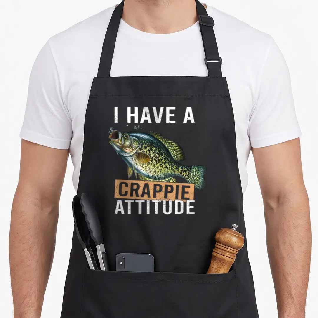 Crappie fishing aprons - Realistic crappie fish with I HAVE A CRAPPIE ATTITUDE text in orange and white — shown on a black cotton canvas apron against a white background
