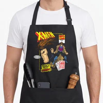 Gambit cajun aprons - Distressed X-Men comic cover with Gambit profile, playing cards, and text Mon Ami Enter — shown on a black cotton canvas apron against a white background