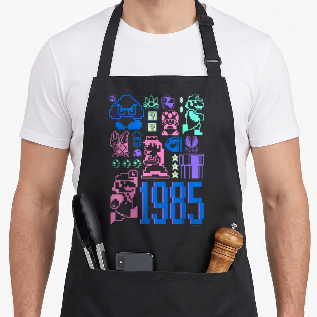 Bro pixel gamer apron - Pixel art characters and 1985 text in blue pink purple on black — shown on a black cotton canvas apron against a white background