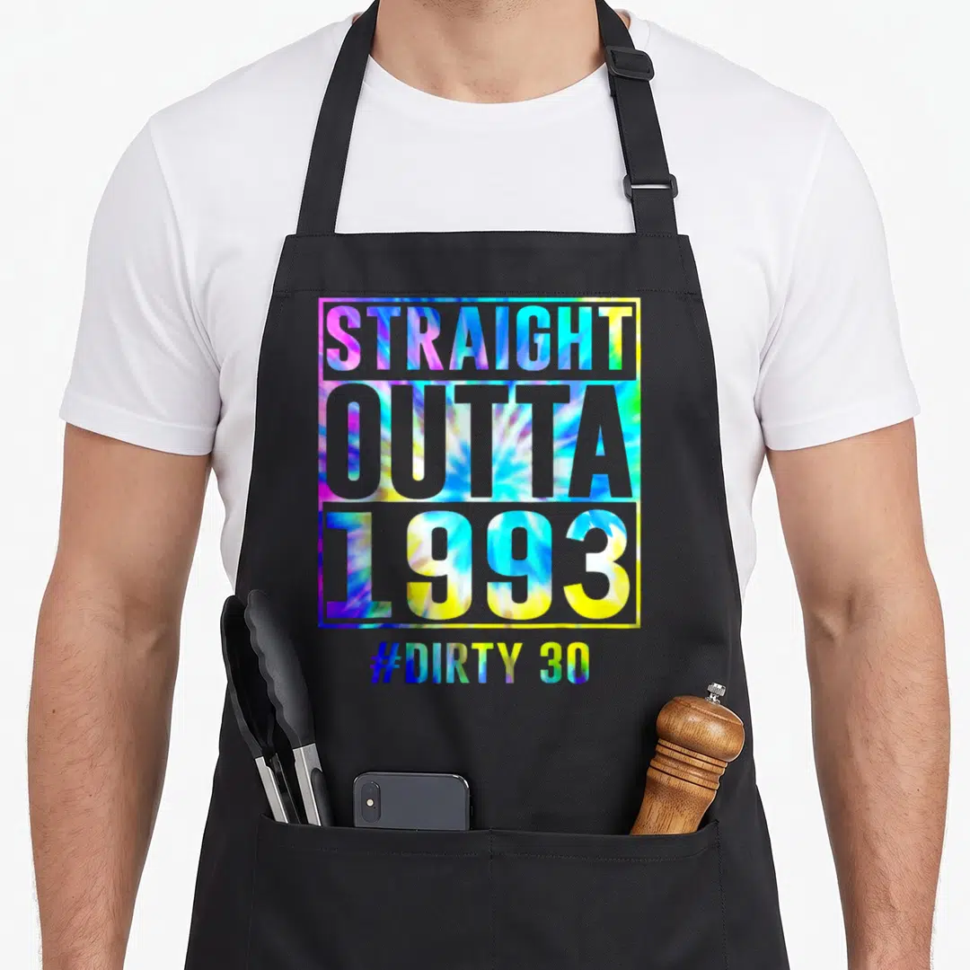 Outta thirty funny dirty aprons - Stacked tie-dye typography reading STRAIGHT OUTTA 1993 and #DIRTY 30 inside a square — shown on a black cotton canvas apron against a white background
