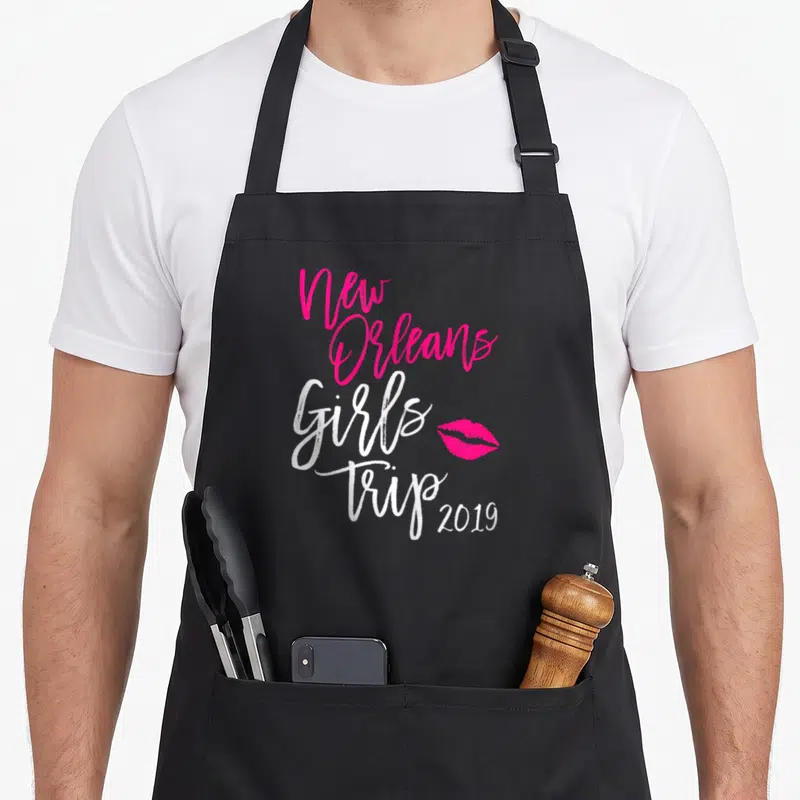 Trip new orleans apron - New Orleans Girls Trip 2019 text with pink lips on black apron — shown on a black cotton canvas apron against a white background