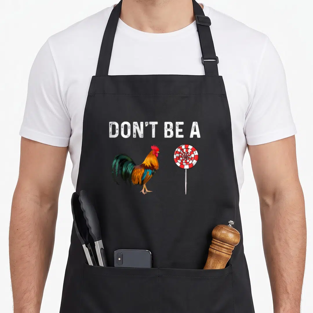 Sucker sarcastic apron - Cartoon rooster and red white swirl lollipop below white text — shown on a black cotton canvas apron against a white background