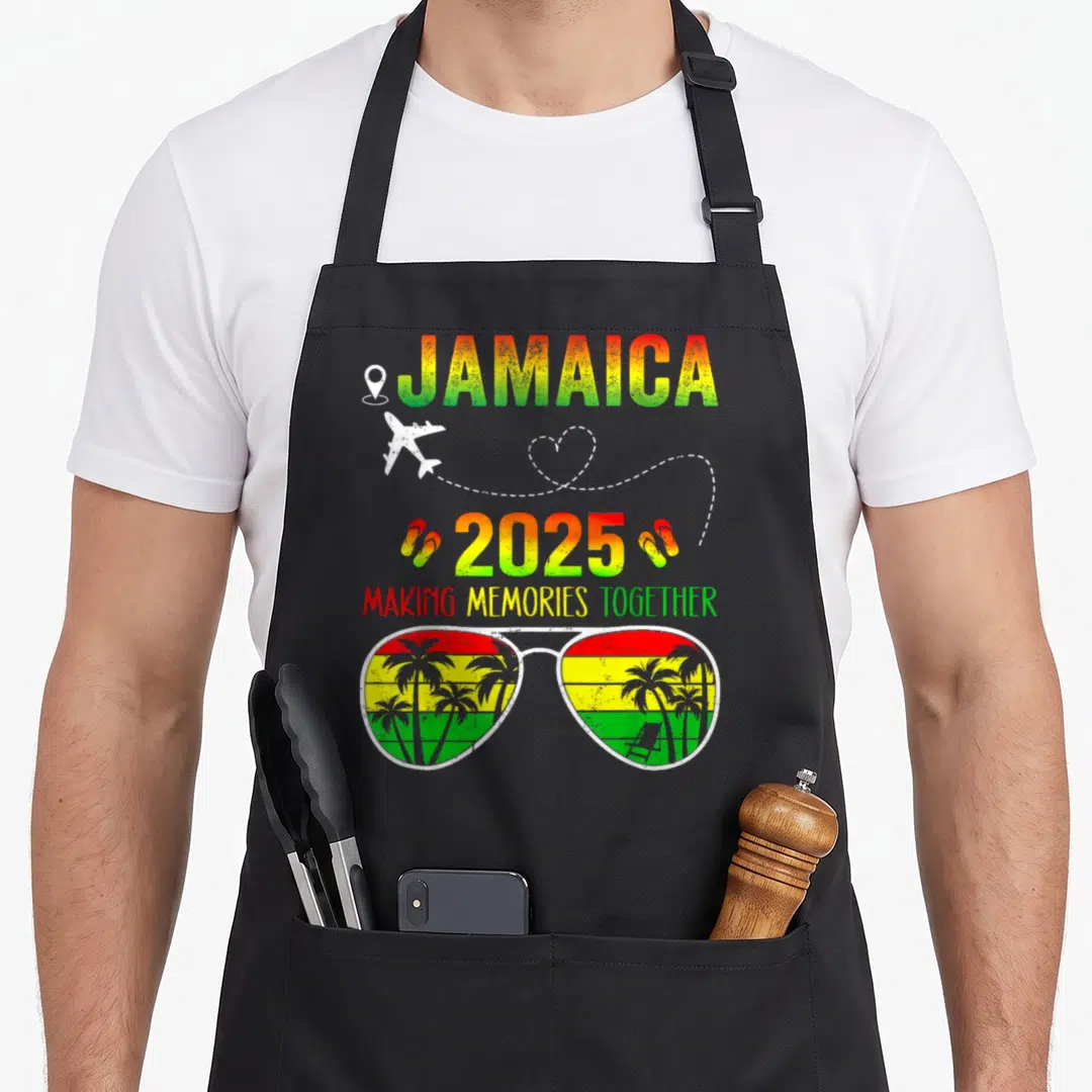 Jamaica family memory apron - Retro 2025 Jamaica apron with sunglasses, airplane, and making memories together text — shown on a black cotton canvas apron against a white background