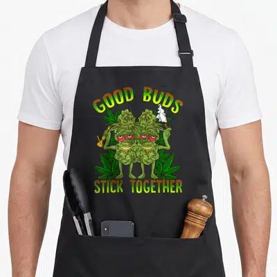 Marijuana couple apron - Two cartoon cannabis buds with red eyes holding a bong and joint under arched text — shown on a black cotton canvas apron against a white background