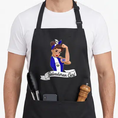 Salvadorena salvadoran apron - Cartoon woman flexing arm with flag tattoo and ribbon reading Salvadoran Girl — shown on a black cotton canvas apron against a white background