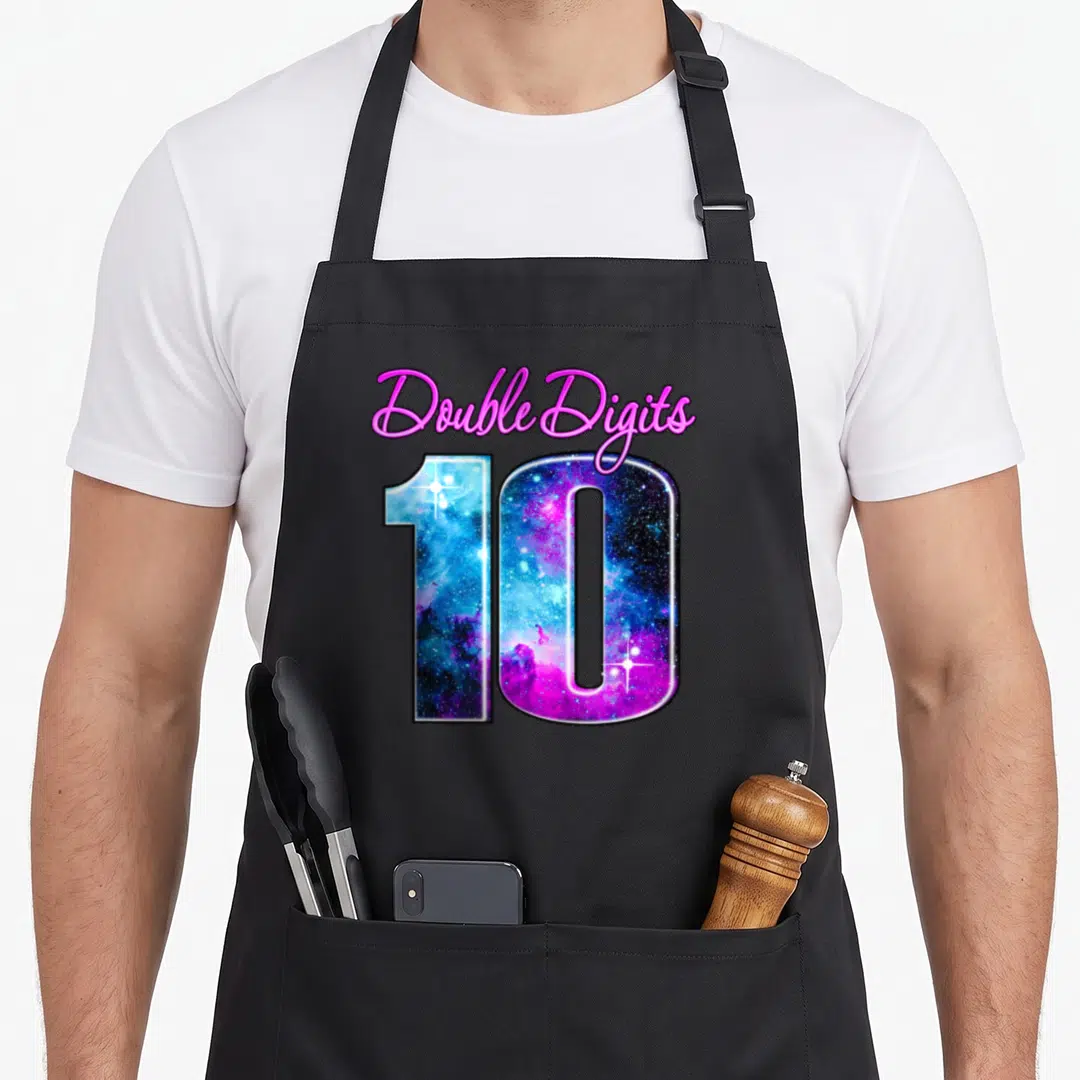 Galaxy double apron - Double Digits 10 text filled with galaxy pattern in pink blue purple — shown on a black cotton canvas apron against a white background