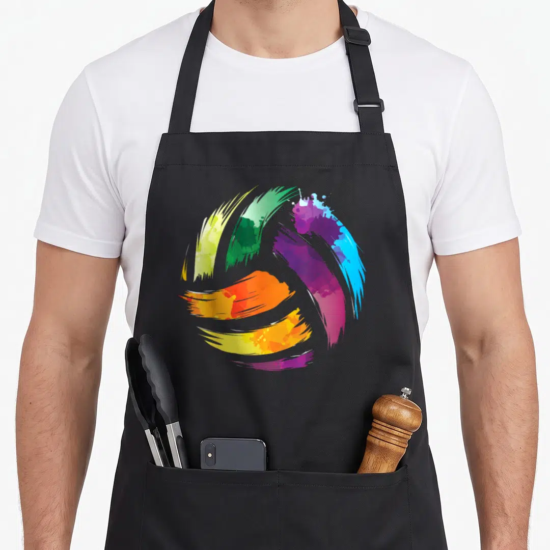 Volleyball colorful aprons - Watercolor volleyball shape made of blue purple green yellow orange and red brushstrokes — shown on a black cotton canvas apron against a white background