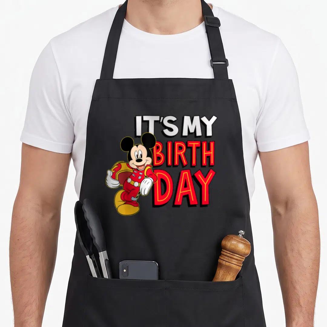Birthday junior apron - Mickey Mouse in red suit next to IT'S MY BIRTHDAY text — shown on a black cotton canvas apron against a white background