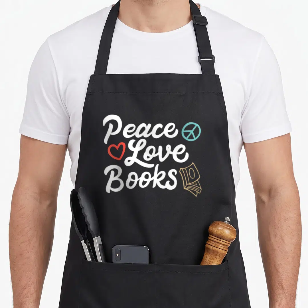 Peace geeky aprons - Stacked text Peace Love Books with peace sign heart and book stack icon — shown on a black cotton canvas apron against a white background