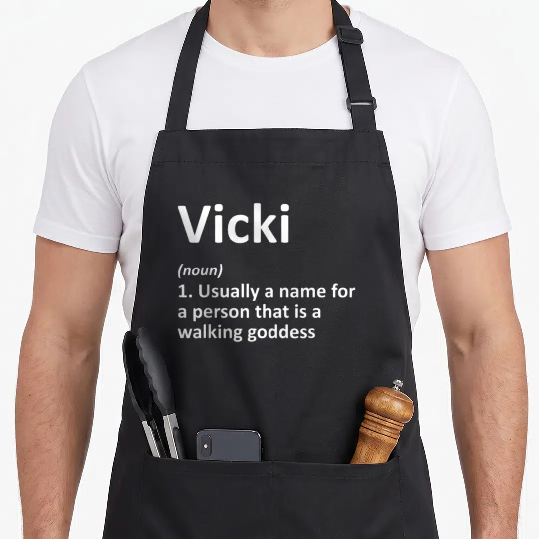 Vicki children's christmas apron - White dictionary definition text reading Vicki usually a name for a person that is — shown on a black cotton canvas apron against a white background