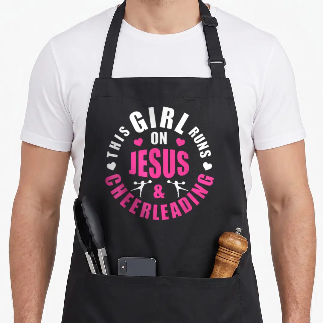 Run cheerleading apron - Circular white and pink text reading THIS GIRL RUNS ON JESUS CHEERLEADING with heart — shown on a black cotton canvas apron against a white background