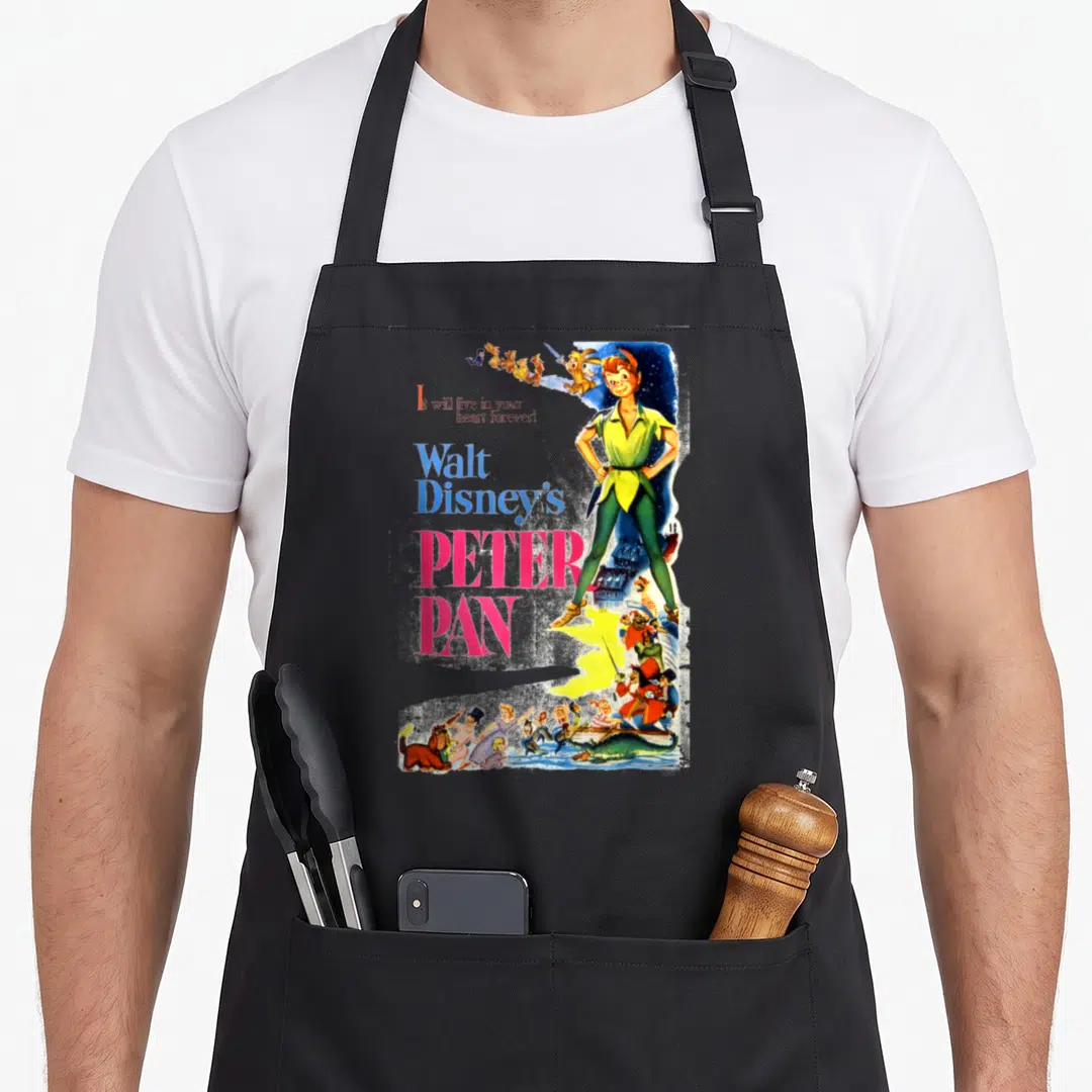Peter cartoon apron - Vintage Peter Pan poster art with stacked text and colorful character figures — shown on a black cotton canvas apron against a white background