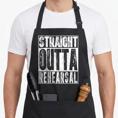 Straight actor apron - White stacked text reading STRAIGHT OUTTA REHEARSAL inside a rectangular border — shown on a black cotton canvas apron against a white background