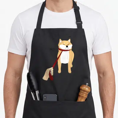 Inu meme apron - Cartoon Shiba Inu dog with red leash and NO text standing centrally — shown on a black cotton canvas apron against a white background