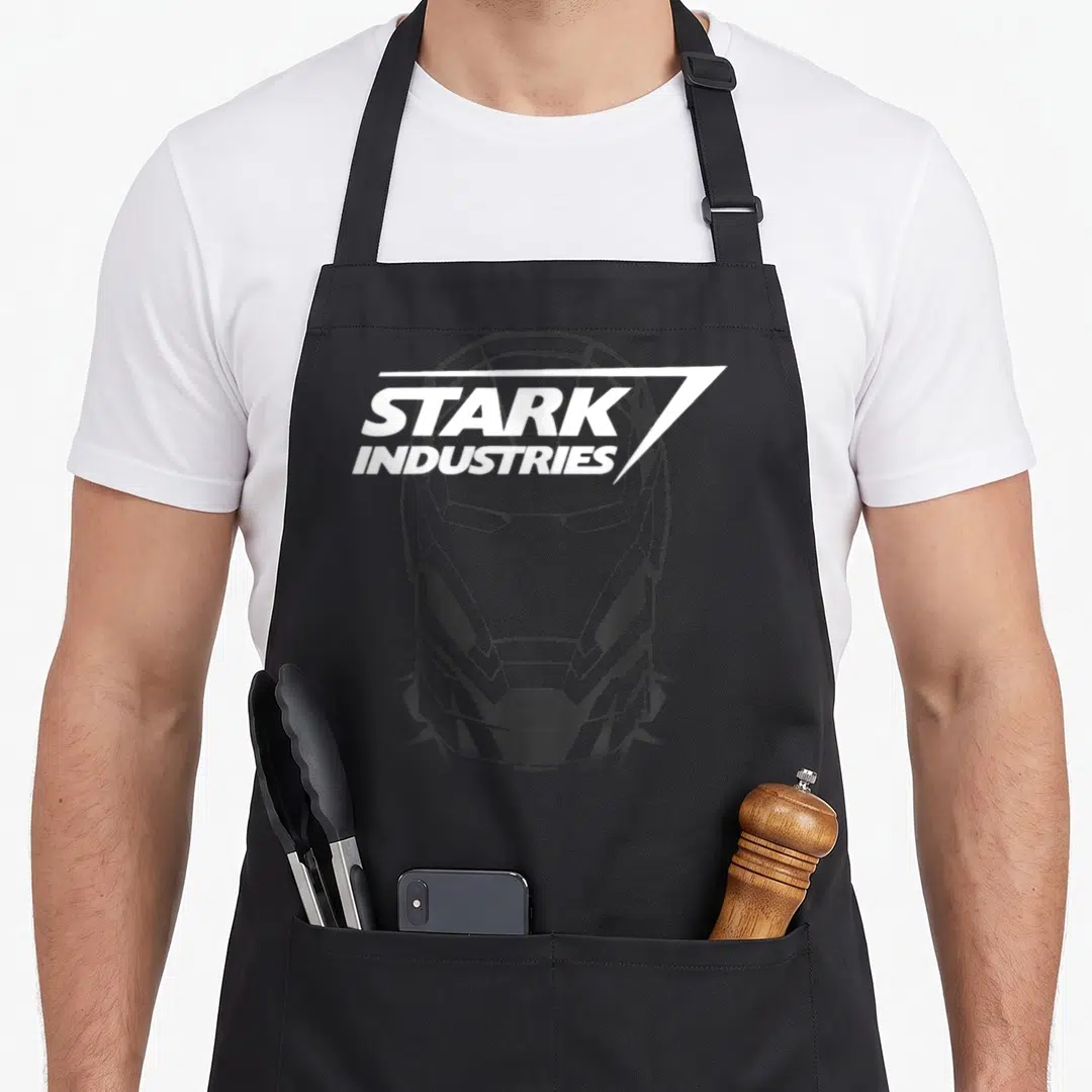 Industry crazy falcon man apron - Minimalist grey Iron Man helmet with white Stark Industries text overlay — shown on a black cotton canvas apron against a white background