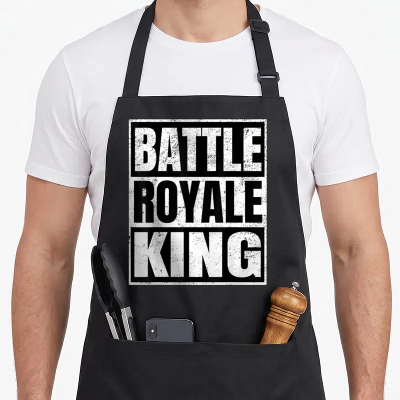 Battle king apron - Stacked BATTLE ROYALE KING text in alternating black and white distressed blocks — shown on a black cotton canvas apron against a white background