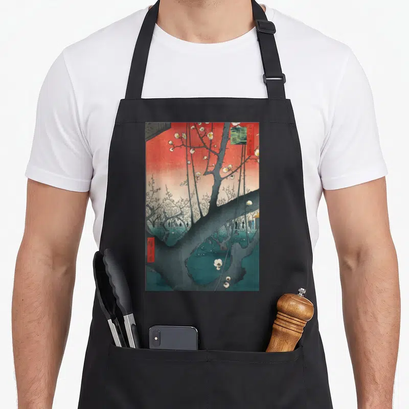 Plum artwork apron - Plum tree with white blossoms, red sky, and small figures in Japanese style — shown on a black cotton canvas apron against a white background