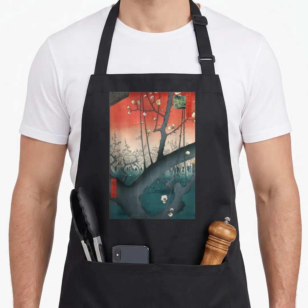 Plum artwork apron - Plum tree with white blossoms, red sky, and small figures in Japanese style — shown on a black cotton canvas apron against a white background