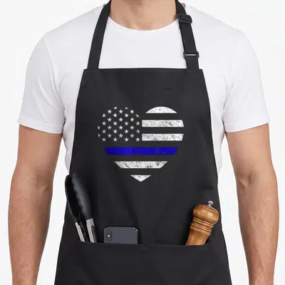 Line american flag apron - Distressed heart shaped USA flag with central blue stripe on black background — shown on a black cotton canvas apron against a white background