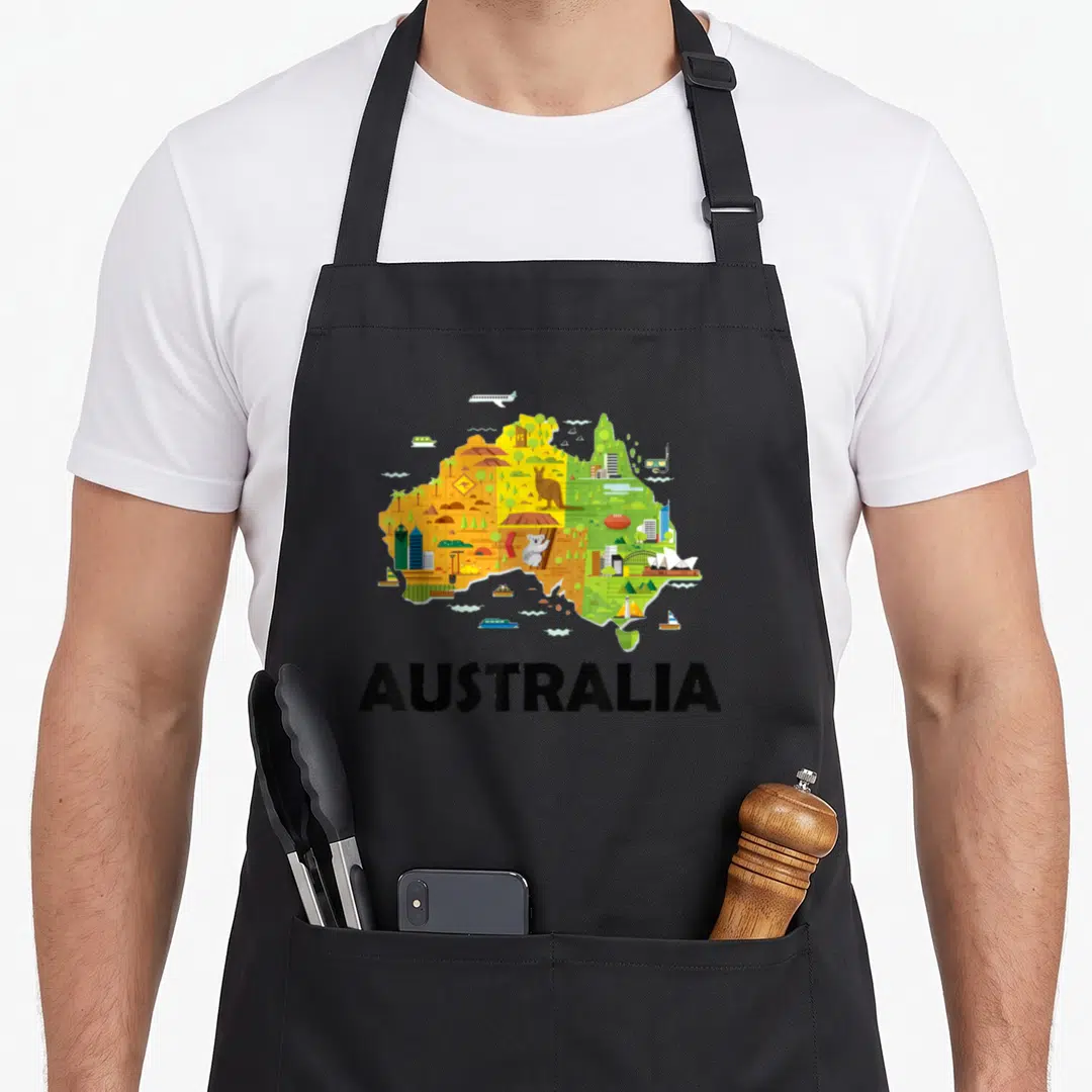 Australia australian apron - Cartoon map of Australia with kangaroo koala icons and AUSTRALIA text in yellow green — shown on a black cotton canvas apron against a white background