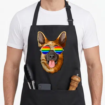 Shepherd flag gay pride apron - Cartoon German Shepherd head wearing aviator sunglasses with rainbow lenses — shown on a black cotton canvas apron against a white background