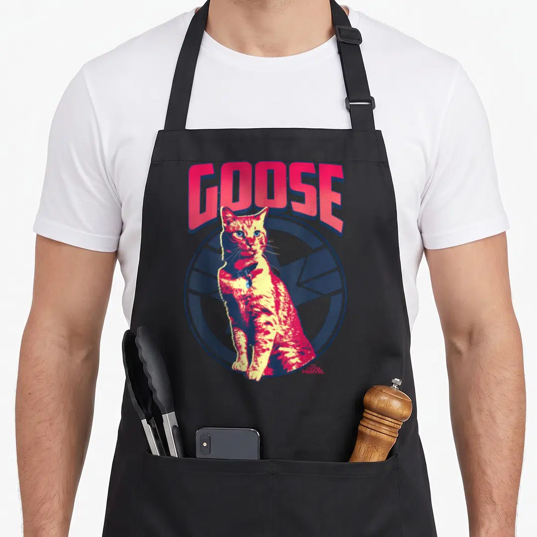 Tonal goose apron - Red and yellow cartoon cat sitting in front of blue circle under red GOOSE text — shown on a black cotton canvas apron against a white background