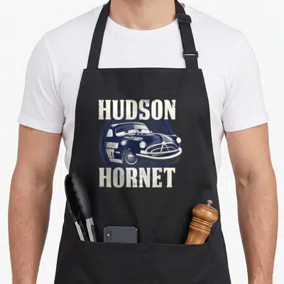 Hudson car apron - Blue cartoon race car with white Hudson Hornet text inside a circle — shown on a black cotton canvas apron against a white background