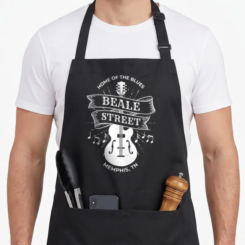Street memphis apron - White guitar with Beale Street ribbon and Home of the Blues text — shown on a black cotton canvas apron against a white background