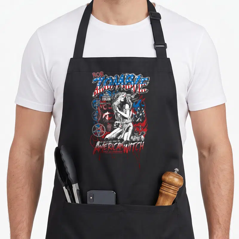 Zombie witch apron - Distressed American flag lettering surrounds a white witch drawing with skulls and pentagrams — shown on a black cotton canvas apron against a white background