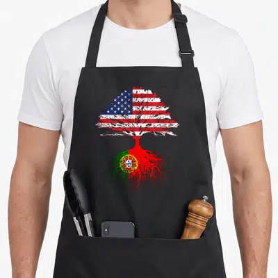 Root portuguese apron - Distressed tree with USA flag canopy and Portugal flag roots — shown on a black cotton canvas apron against a white background
