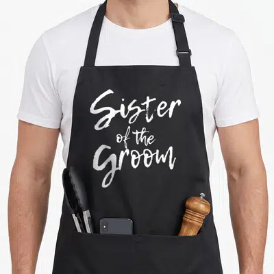 Shower bridal apron - White Sister of the Groom stacked calligraphy text design — shown on a black cotton canvas apron against a white background