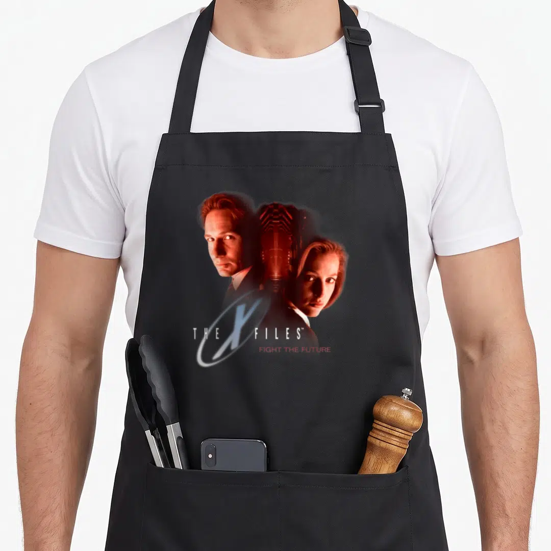 Mulder 90s apron - THE X FILES and FIGHT THE FUTURE text with two people and glowing ring — shown on a black cotton canvas apron against a white background