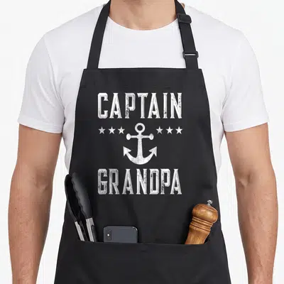 Captain grandpa apron - White distressed anchor and star graphic with Captain Grandpa text — shown on a black cotton canvas apron against a white background