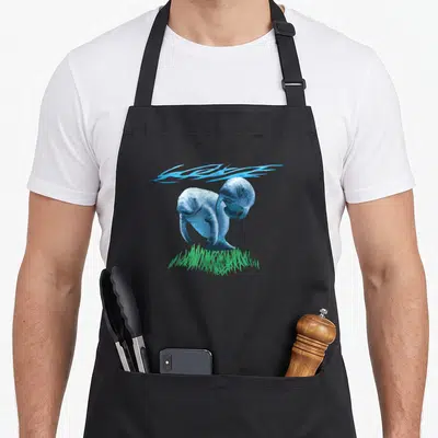Cute manatee apron - Two blue manatees with green seagrass and blue water splashes — shown on a black cotton canvas apron against a white background