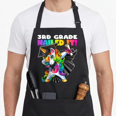 Gown unicorn apron - Dabbing unicorn in cap gown holding diploma with 3rd Grade Nailed It text — shown on a black cotton canvas apron against a white background