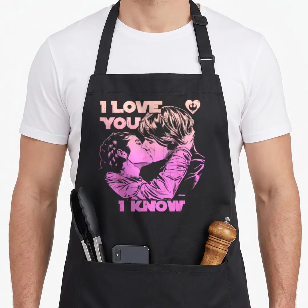 Han i love stars apron - Retro pink and orange couple kissing with I LOVE YOU I KNOW text and Rebel Alliance heart logo — shown on a black cotton canvas apron against a white background