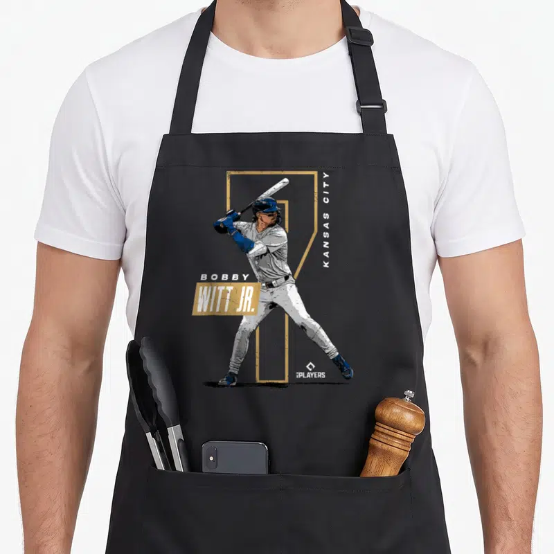 Bobby baseball apron - Bobby Witt Jr standing photo graphic with gold number and vertical Kansas City text — shown on a black cotton canvas apron against a white background