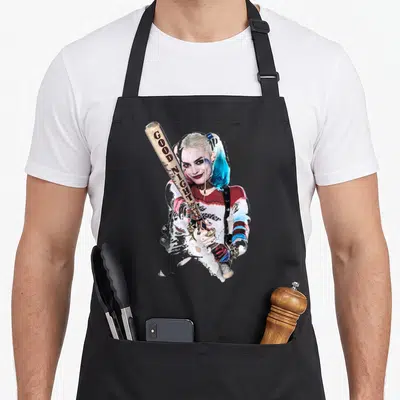 Suicide bat apron - Harley Quinn photo holding baseball bat with GOOD NIGHT text in red and blue — shown on a black cotton canvas apron against a white background