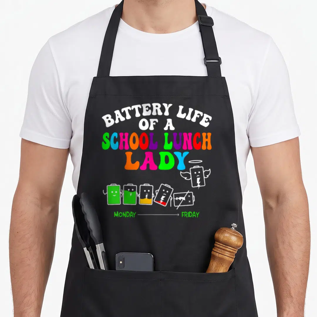 Battery lunch lady apron - Stacked rainbow text above six cartoon batteries fading from full green charge to a white — shown on a black cotton canvas apron against a white background