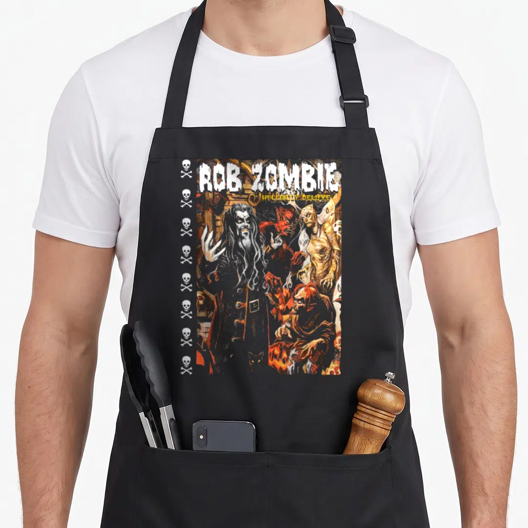 Hellbilly zombie apron - Rob Zombie Hellbilly Deluxe print with central man, monsters, and vertical skull column — shown on a black cotton canvas apron against a white background