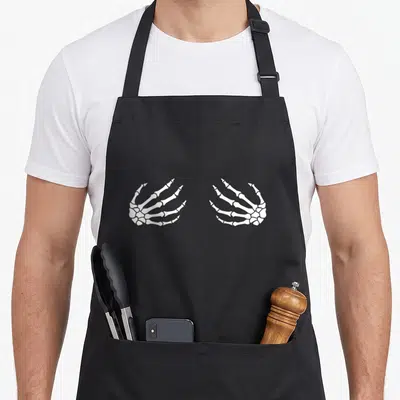 Skeleton halloween apron - Two white skeleton hands facing inward in black line art on grey background — shown on a black cotton canvas apron against a white background