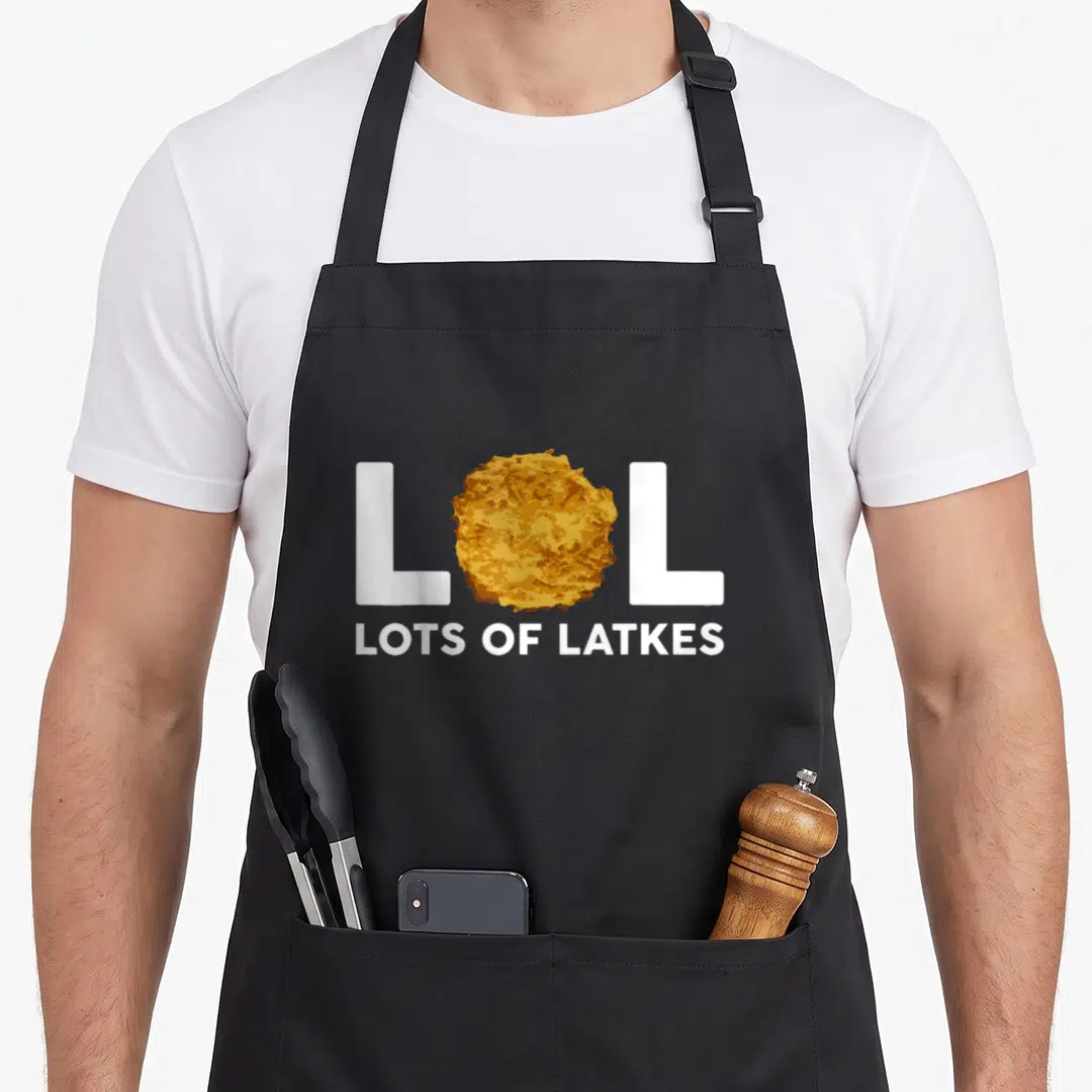 Lol hanukkah apron - Latke graphic replaces O in white LOL text above LOTS OF LATKES slogan — shown on a black cotton canvas apron against a white background